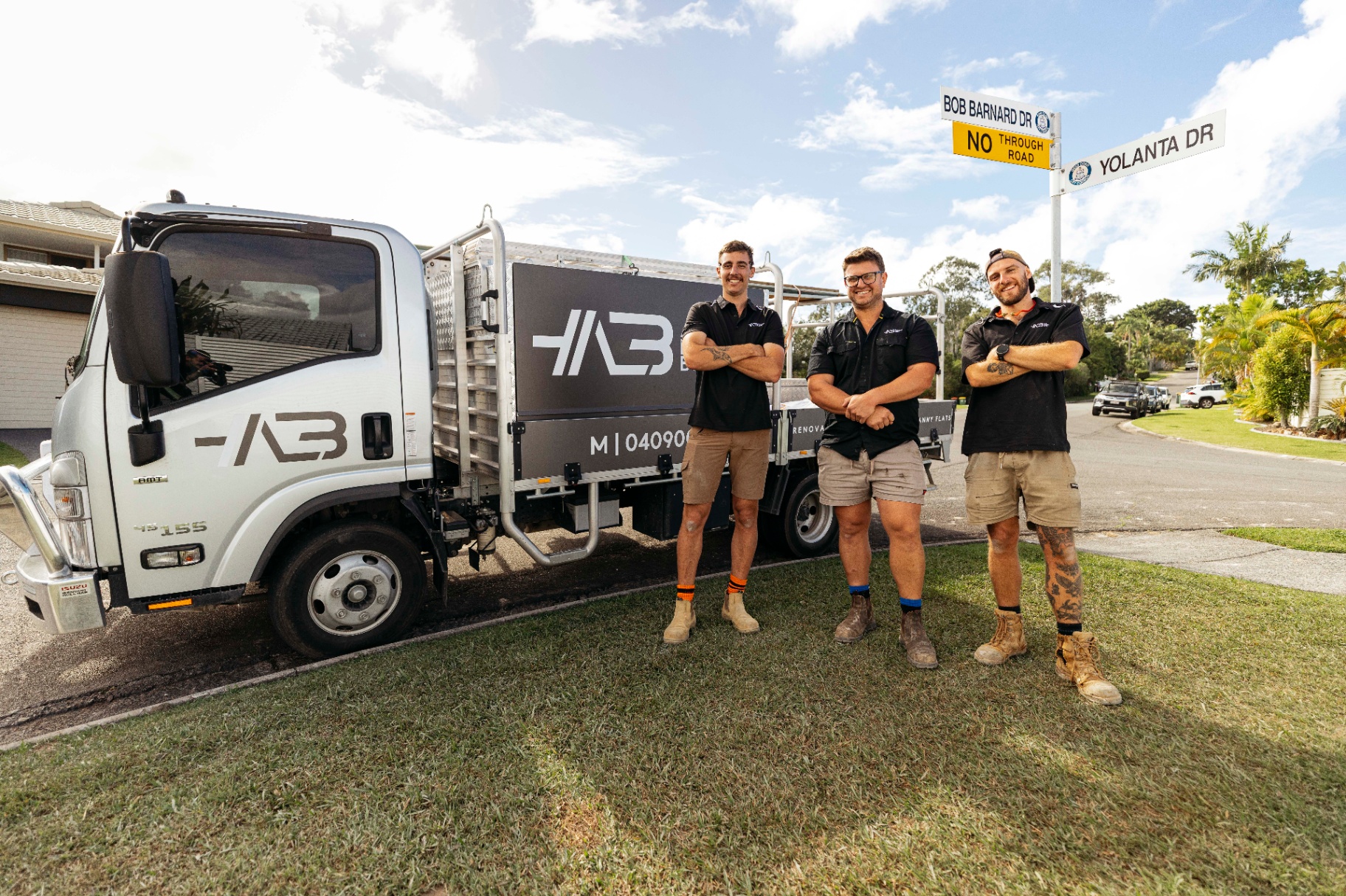 The All Leonard Build team standing in front of the company truck on a Gold Coast street.