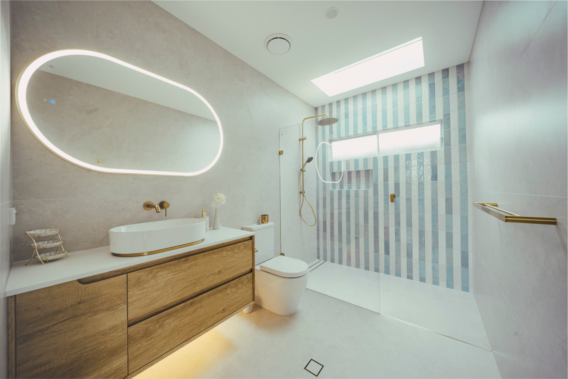 Renovated bathroom with backlit mirror, timber vanity and striped tiled shower.
