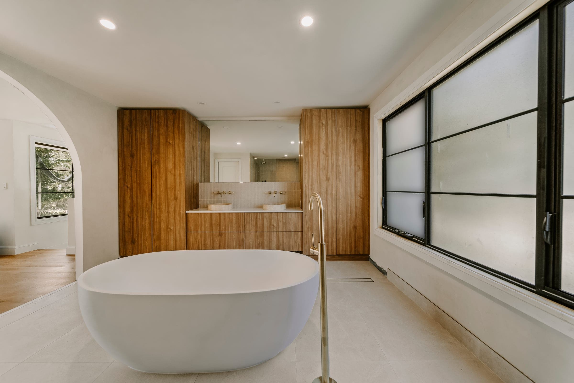 A Gold Coast custom home built by All Leonard Build, set within tropical landscape at golden hour.