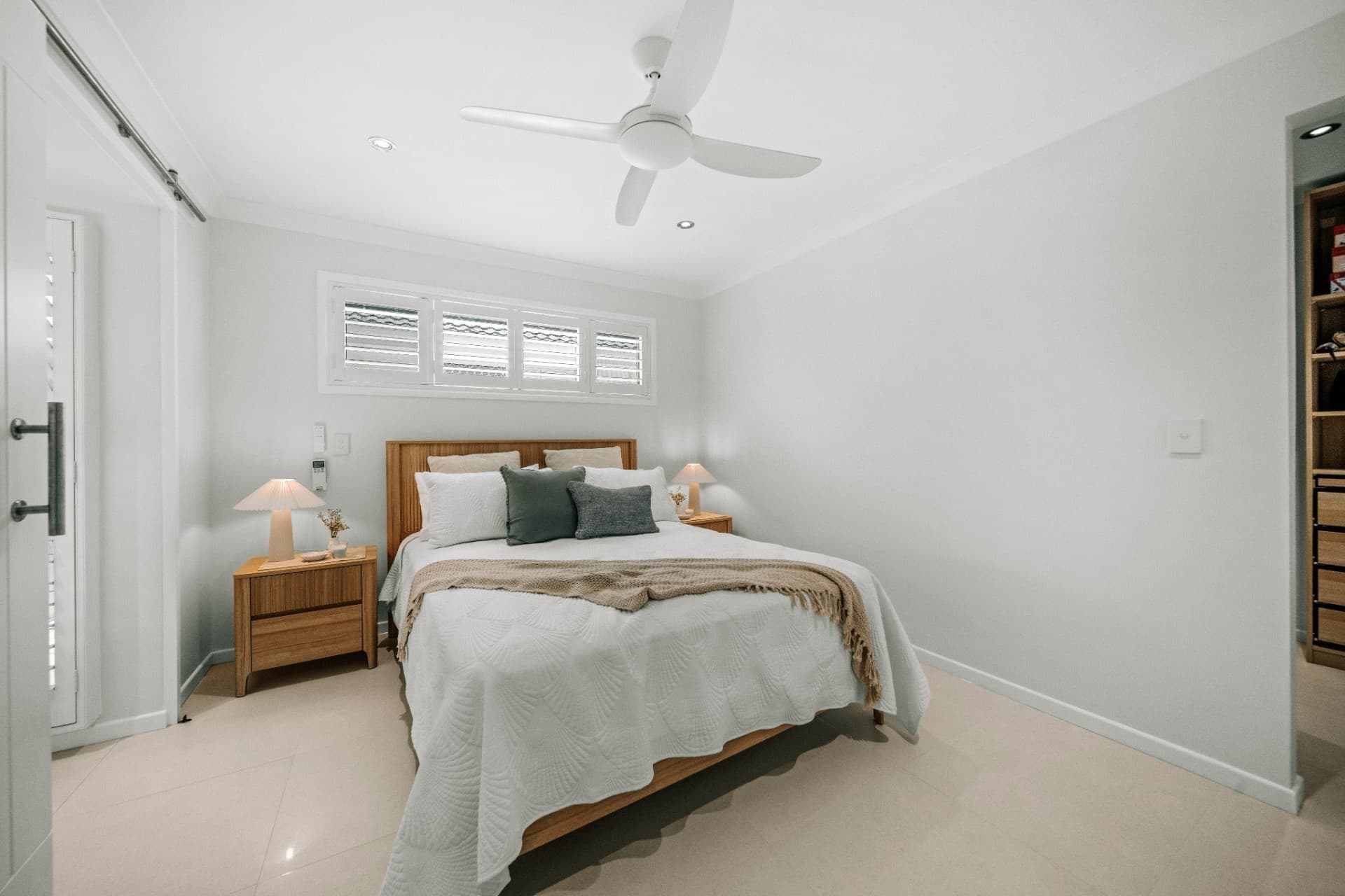 Mermaid Waters main bedroom with timber bedhead, plantation shutters and ceiling fan.