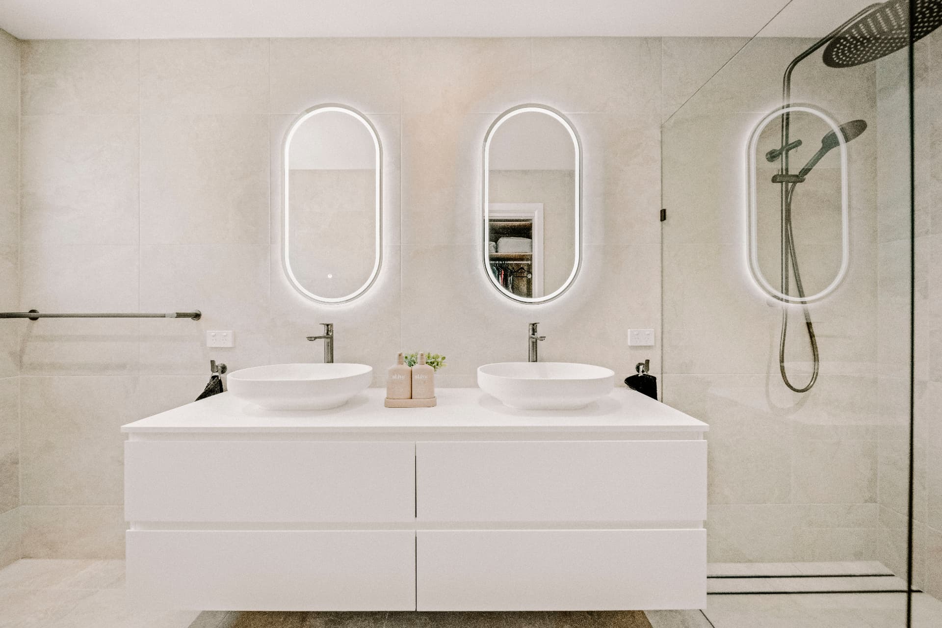 Mermaid Waters second dwelling ensuite with twin LED oval mirrors, vessel basins and walk-in shower.