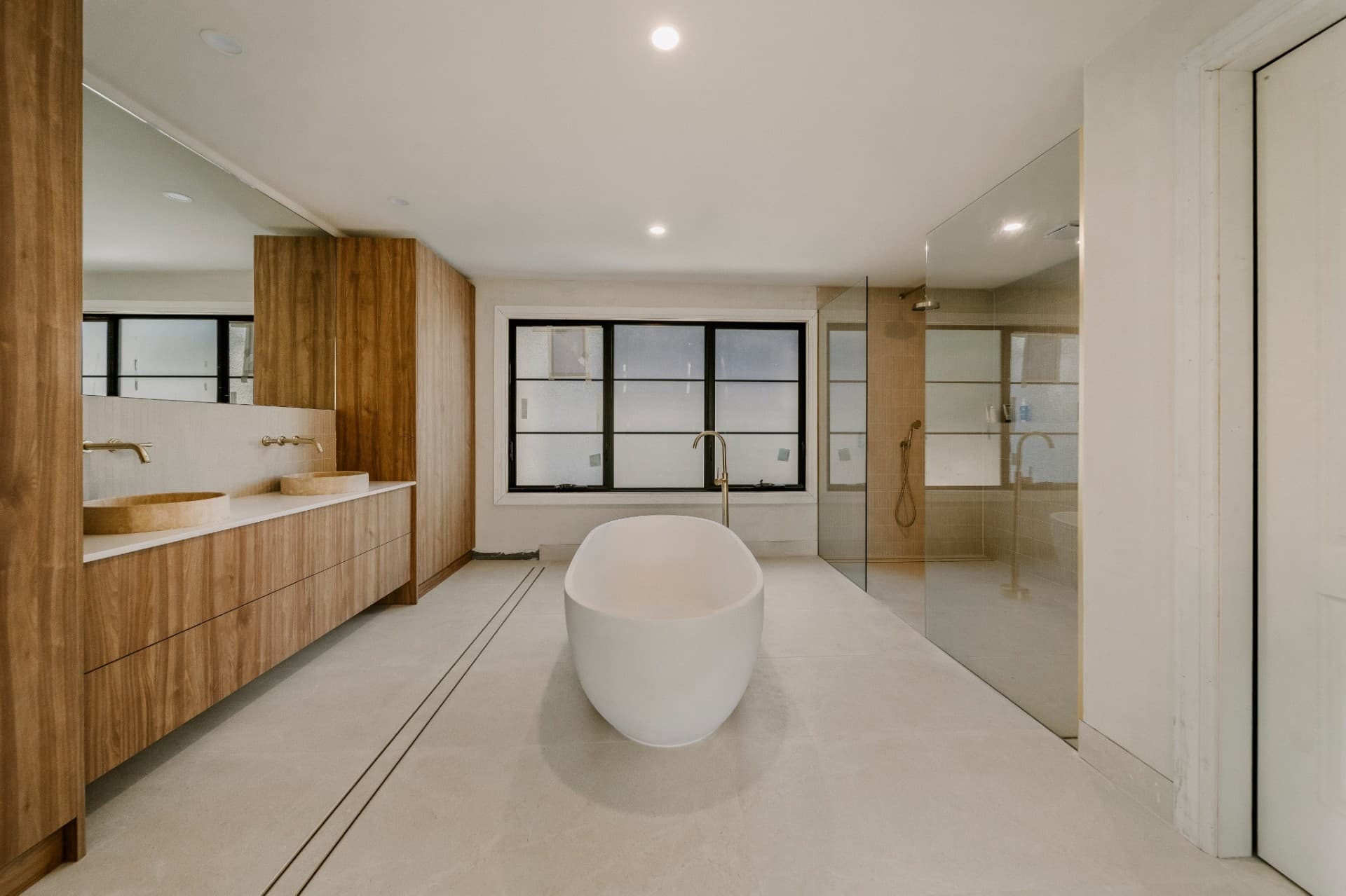 Yandala main bathroom with freestanding tub, twin stone basins and timber joinery.